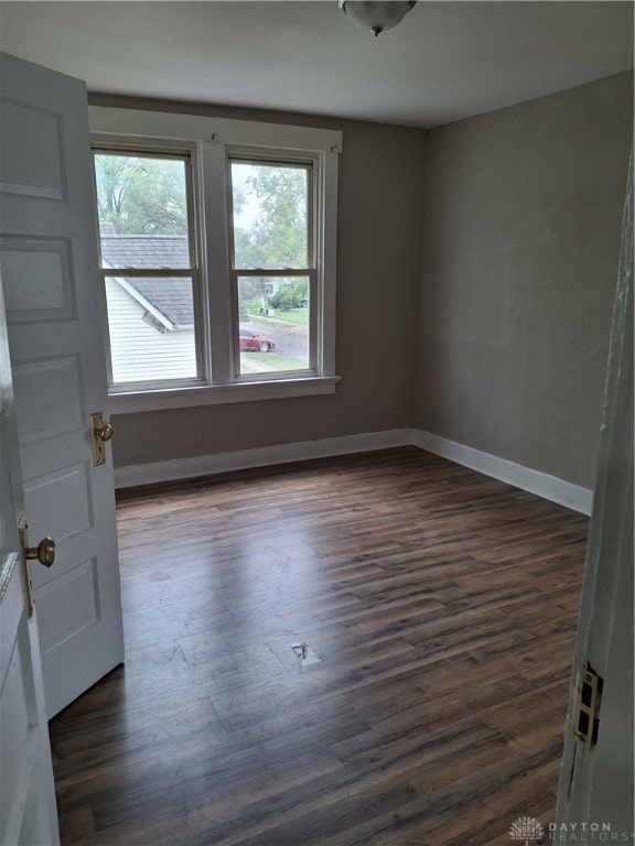 spare room featuring dark wood-type flooring