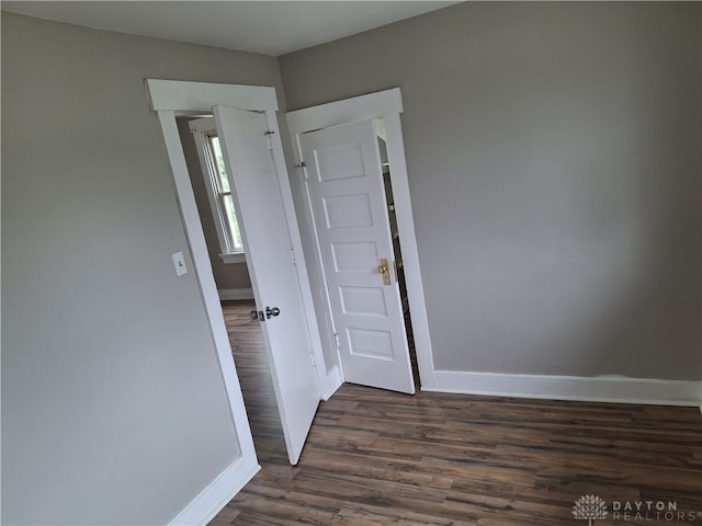 unfurnished room with dark wood-type flooring