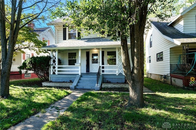 bungalow-style home with a front lawn and covered porch