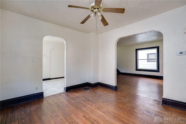 spare room featuring ceiling fan and dark wood-type flooring