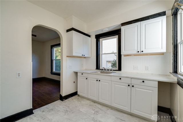 kitchen with white cabinetry, sink, and light hardwood / wood-style flooring