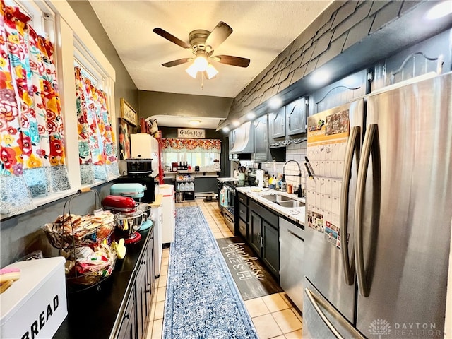 kitchen with ceiling fan, light tile patterned floors, appliances with stainless steel finishes, and sink