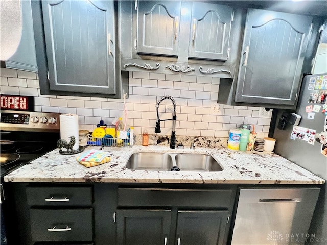 kitchen with light stone counters, dishwasher, sink, electric stove, and decorative backsplash