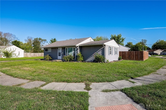 ranch-style house featuring a front lawn and fence