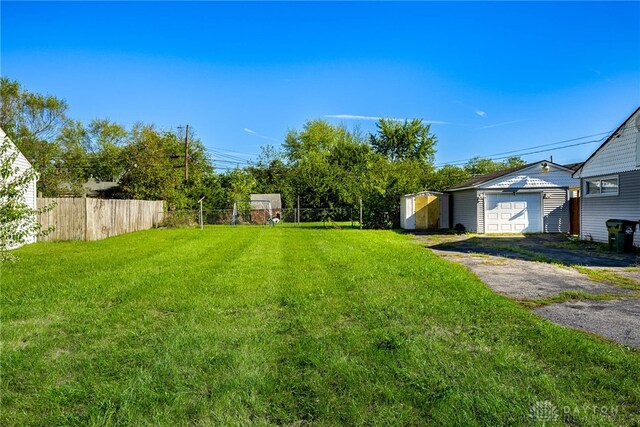 view of yard featuring a garage and an outbuilding