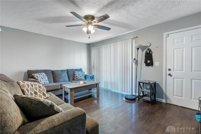 living room featuring dark wood finished floors, ceiling fan, and a textured ceiling