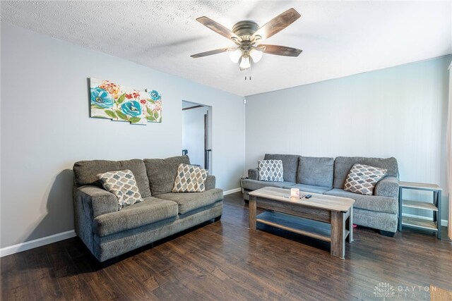 living room featuring a textured ceiling, dark hardwood / wood-style floors, and ceiling fan