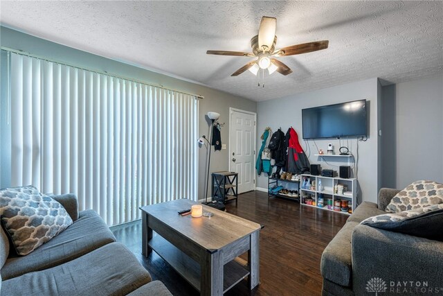 living room with ceiling fan, a textured ceiling, and dark hardwood / wood-style floors