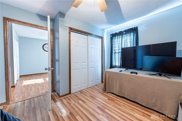 home office with light wood finished floors, baseboards, and a ceiling fan