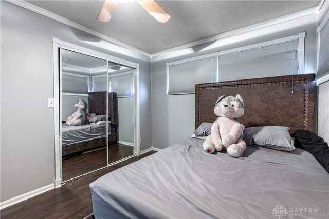 bedroom featuring a textured ceiling, dark hardwood / wood-style floors, a closet, ornamental molding, and ceiling fan