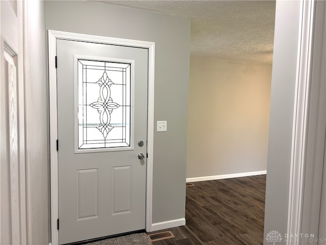 entryway with a textured ceiling and dark hardwood / wood-style floors