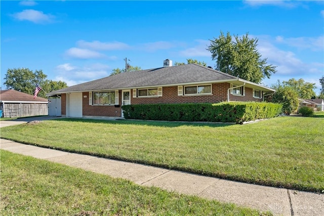 ranch-style home with a front yard, an attached garage, brick siding, and a chimney