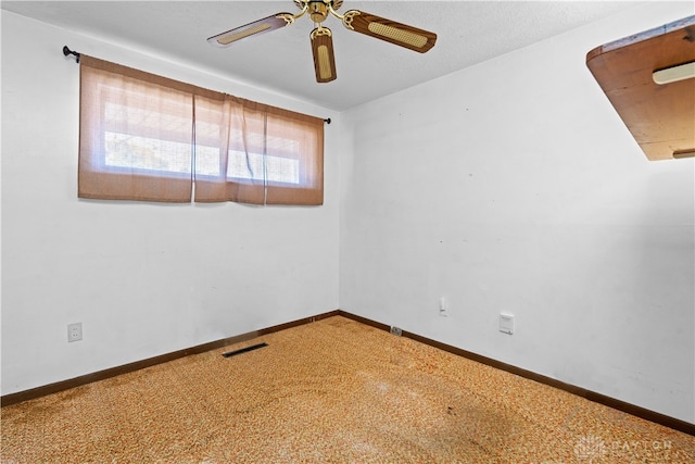 carpeted spare room featuring ceiling fan and a textured ceiling