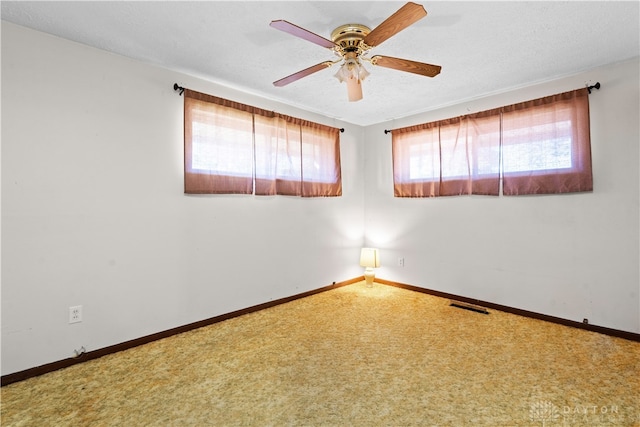 carpeted empty room with ceiling fan and a textured ceiling