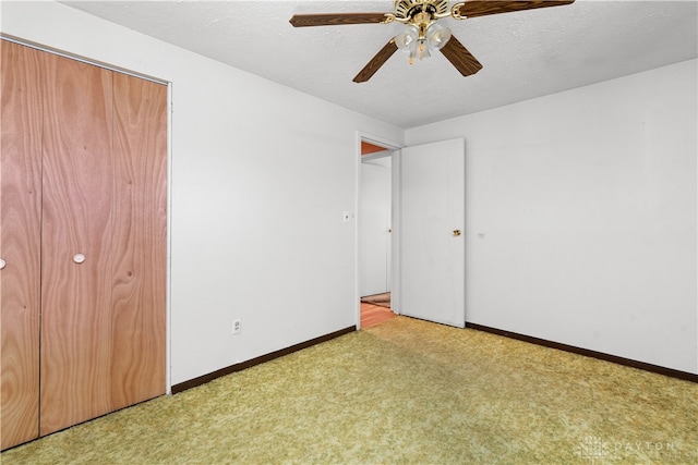 unfurnished bedroom with a textured ceiling, ceiling fan, light colored carpet, and a closet