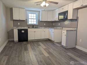 kitchen featuring white cabinetry, black appliances, and dark wood-type flooring