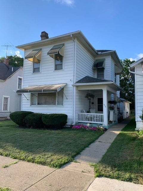 view of front of house with a front yard and covered porch