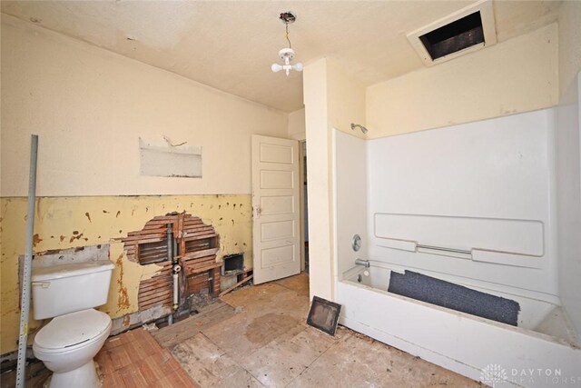 bathroom featuring a chandelier, toilet, and washtub / shower combination