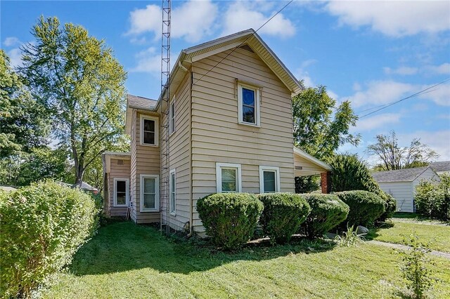 view of side of home with a yard