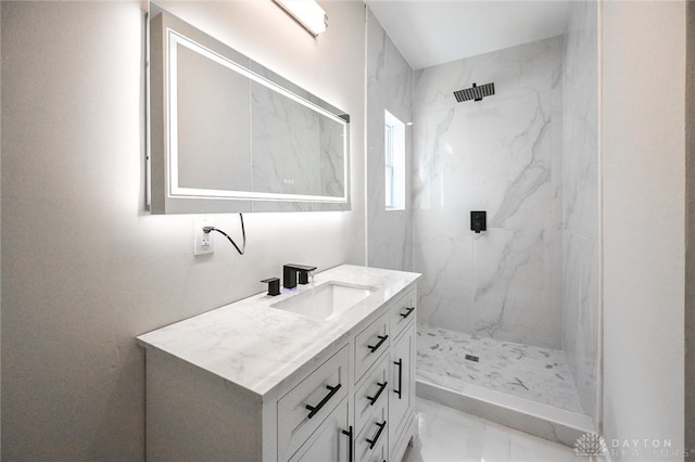 bathroom featuring tiled shower and vanity