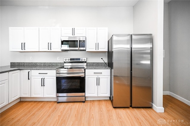 kitchen featuring appliances with stainless steel finishes, white cabinetry, and light hardwood / wood-style flooring