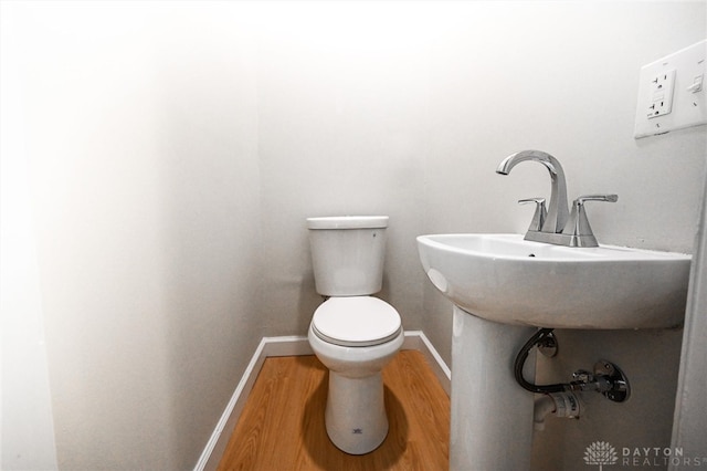 bathroom with hardwood / wood-style flooring and toilet