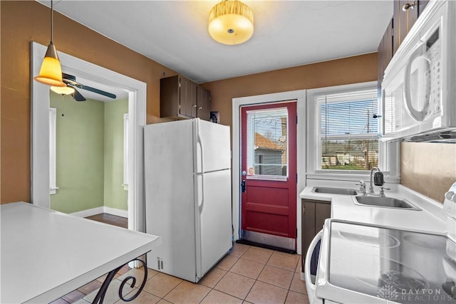 kitchen with white appliances, ceiling fan, sink, light tile patterned floors, and decorative light fixtures