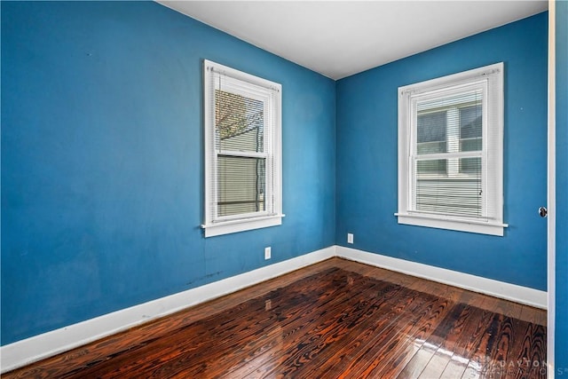 empty room with a healthy amount of sunlight and wood-type flooring