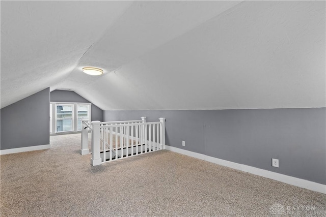 additional living space with carpet flooring and lofted ceiling