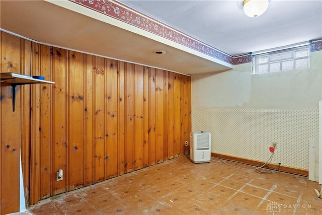 basement featuring wooden walls