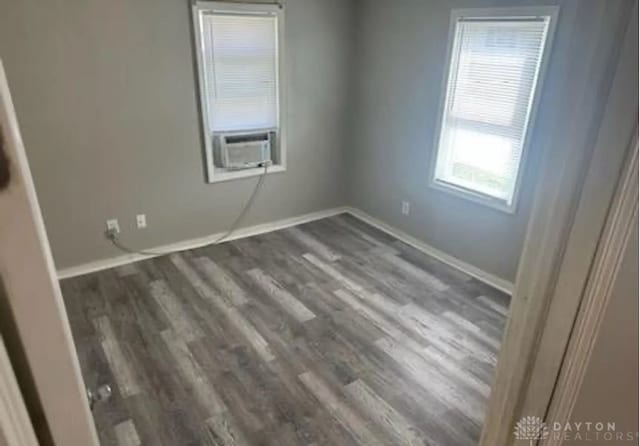 empty room with cooling unit and dark wood-type flooring