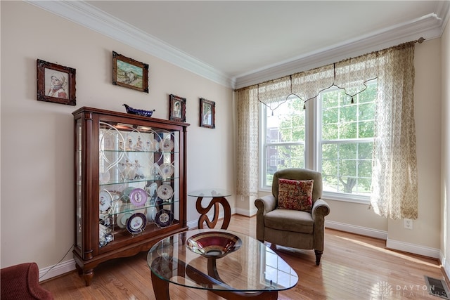 sitting room featuring light wood-type flooring and crown molding