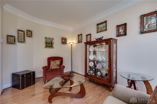 living area featuring ornamental molding and light hardwood / wood-style flooring