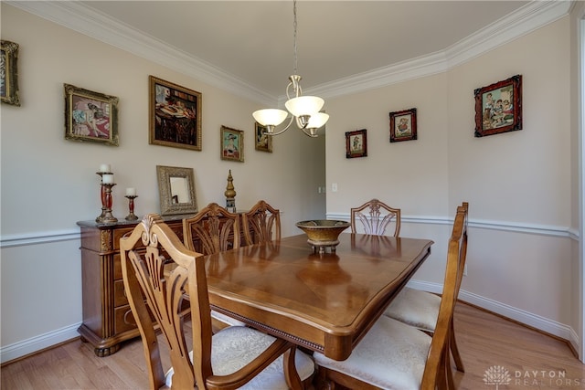 dining room with an inviting chandelier, light hardwood / wood-style floors, and ornamental molding