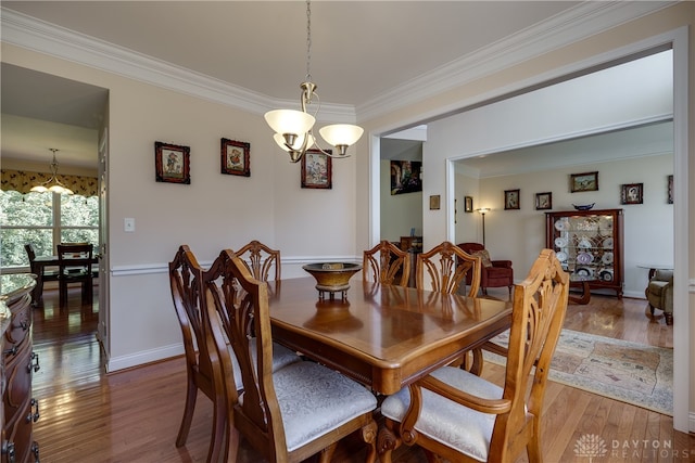 dining area featuring ornamental molding, hardwood / wood-style flooring, and a chandelier