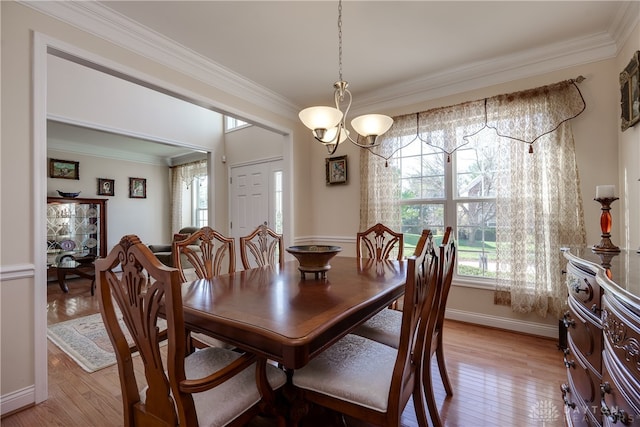 dining room featuring crown molding, hardwood / wood-style floors, and an inviting chandelier