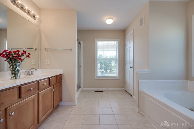 bathroom featuring vanity, plus walk in shower, and tile patterned flooring