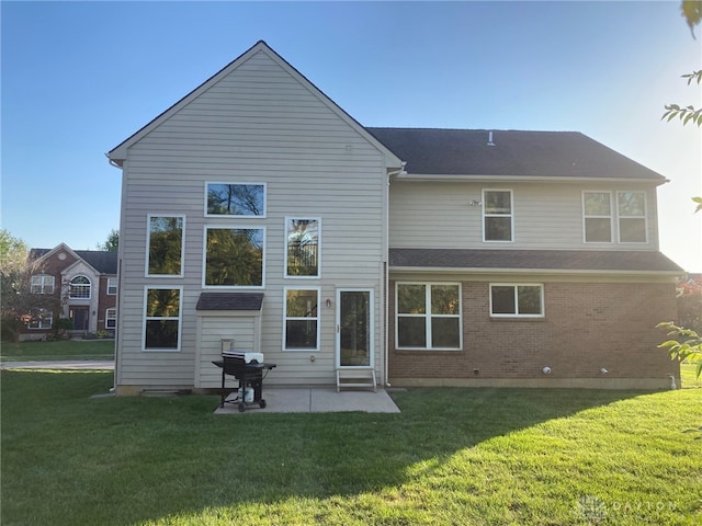 back of property featuring a lawn and a patio