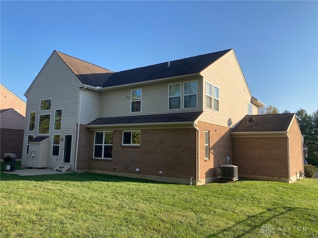 rear view of property featuring a yard, central air condition unit, and a patio