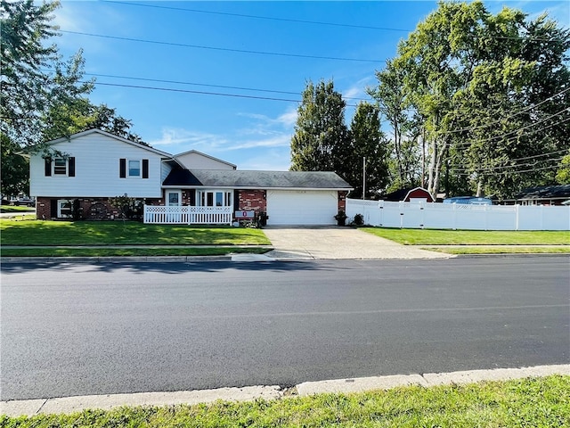 tri-level home featuring a garage and a front lawn