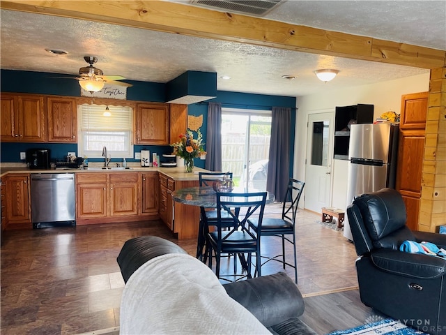 kitchen with dark hardwood / wood-style flooring, stainless steel appliances, a textured ceiling, ceiling fan, and sink