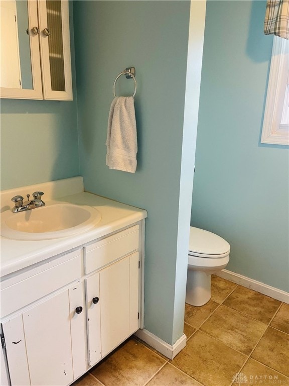 bathroom with tile patterned flooring, vanity, and toilet