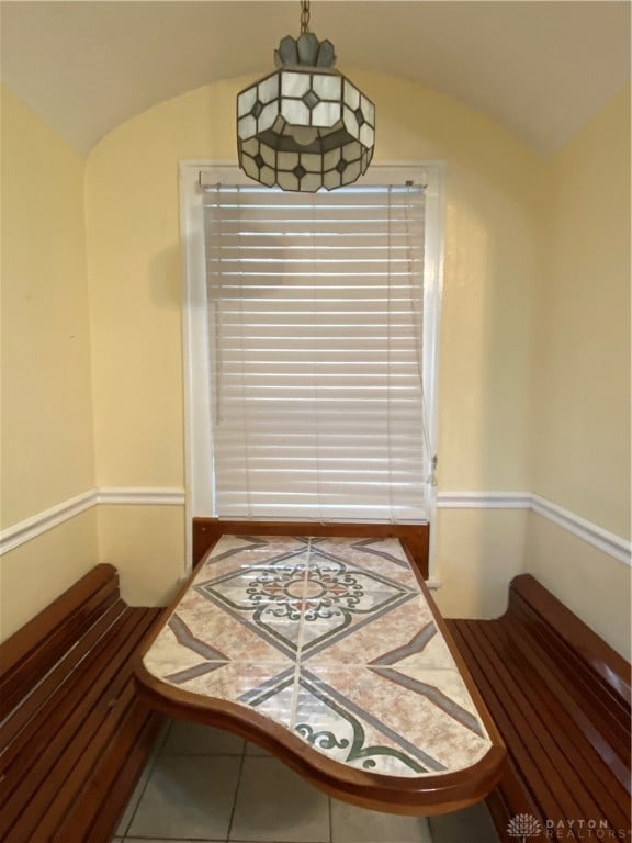 dining space featuring tile patterned flooring and lofted ceiling