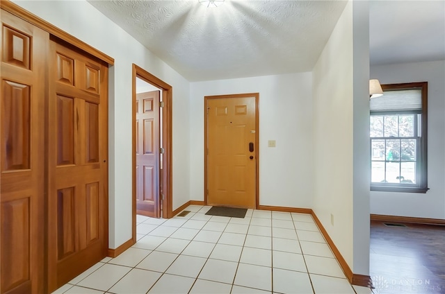 entrance foyer with a textured ceiling and light tile patterned floors