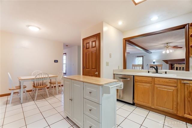 kitchen featuring a center island, sink, light tile patterned floors, wooden counters, and stainless steel dishwasher