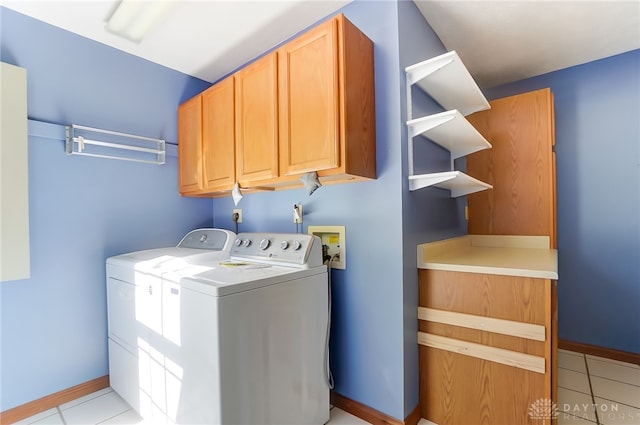 laundry area with light tile patterned flooring, washing machine and clothes dryer, and cabinets