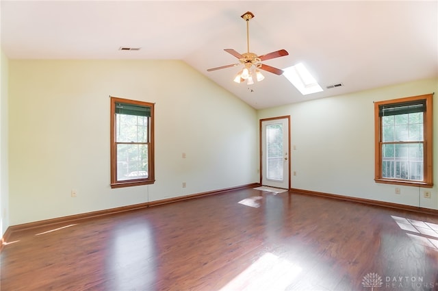 unfurnished room featuring a wealth of natural light, dark wood-type flooring, and vaulted ceiling with skylight