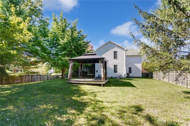 rear view of property featuring a gazebo, a yard, and a wooden deck