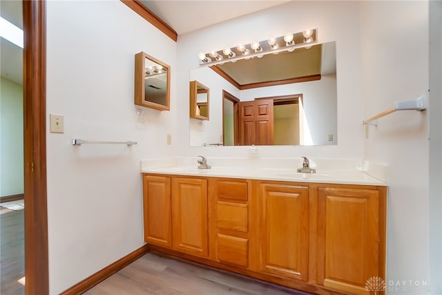 bathroom featuring vanity, ornamental molding, and hardwood / wood-style flooring