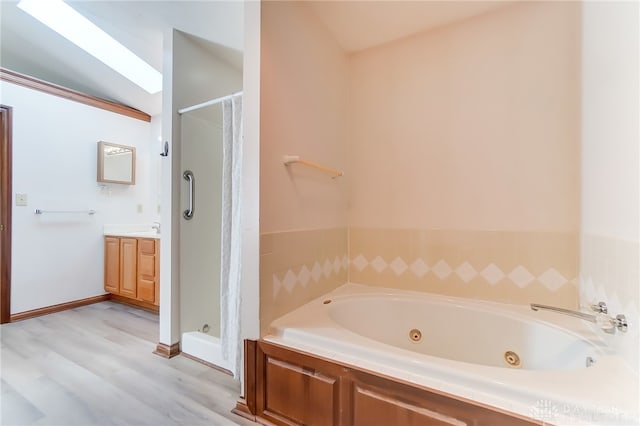 bathroom with vaulted ceiling with skylight, wood-type flooring, independent shower and bath, and vanity